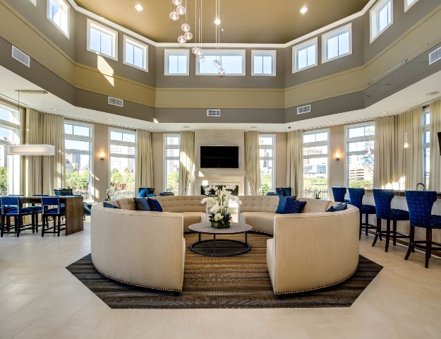 The residents’ lounge at Water’s Edge is one of the community’s many indoor and outdoor amenity spaces, featuring a bar, flat screen television, fireplace and riverfront views.